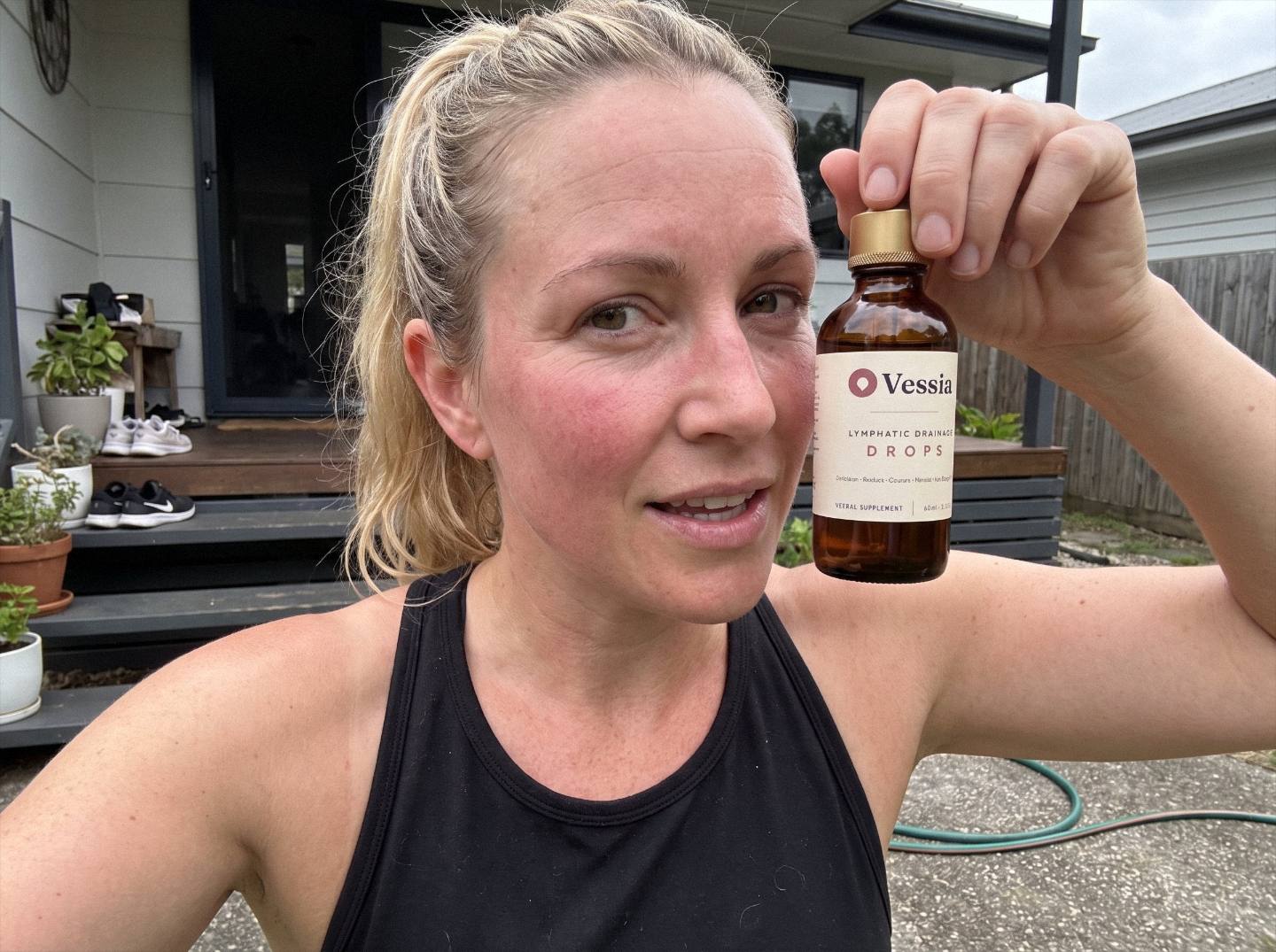 Steph K. holding Vessia Lymphatic Drainage Drops